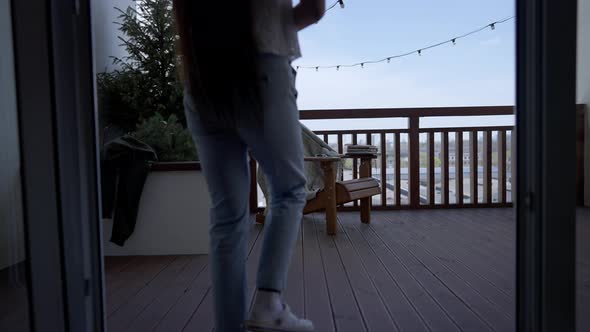 Slim Young Asian Woman Walking to Wooden Armchair on Deck Sitting Down and Opening Laptop / Videohive