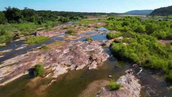 Aerial footage of the popular area on the Llano River in Texas called The Slab. Camera is moving fas