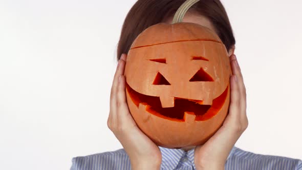 Woman Hiding Behind Carved Halloween Pumpkin Isolated