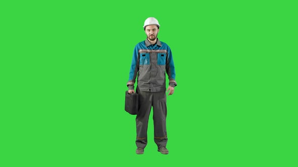 Construction Engineer with Tablet and Drawing in Hands, Man Walks at Camera on a Green Screen alt