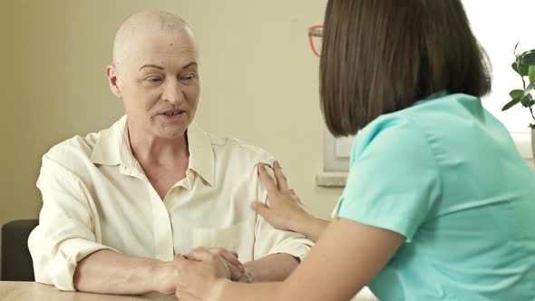 Female Oncologist is Trying to Cheer Up an Elderly Woman with Cancer