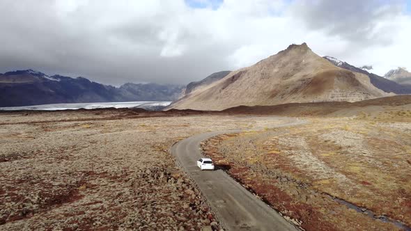 Aerial Shot Following a Car up a Dirt Road.