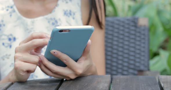 Woman using cellphone at outdoor cafe 