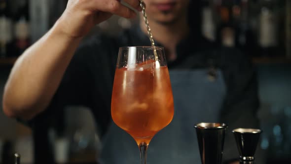 The Barman Pours Aperol Into the Cocktail of Aperol Spritz Close Up Bartender Make Alcohol Drink