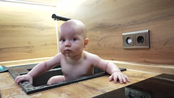 Baby in Kitchen Sink Bathing and Playing with Water