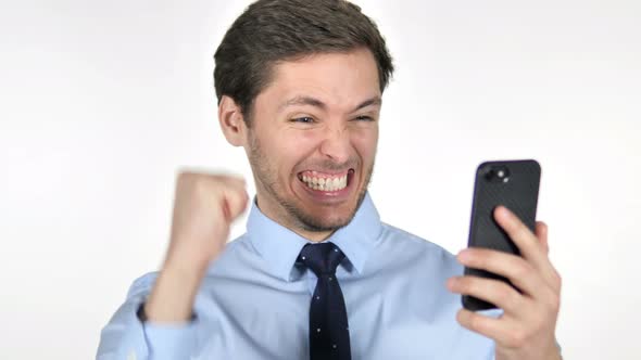 Young Businessman Celebrating Success while Using Smartphone on White Background