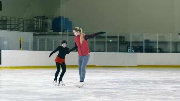 Figure skating trainer teaching little girl to step on ice