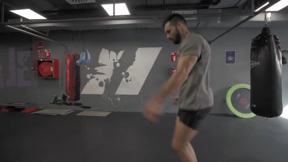 Young athletic man skipping a rope at the gym