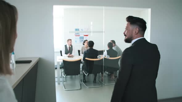 Receptionist Helping Man To Find Board Room