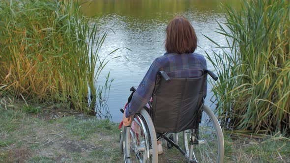 Elderly Woman Sit on Wheelchair Near Lake