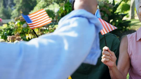 Family holding american flags in the park 4k