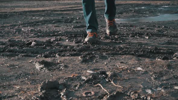 Man in Boots Walks Through the Mud Splashing From a Puddle in Slowmo