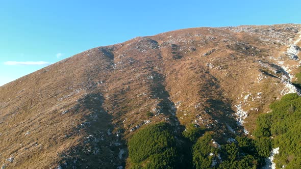 Circular pan of mountain top. Drone shot of peak in julian alps. Grassy slope in Slovenia.