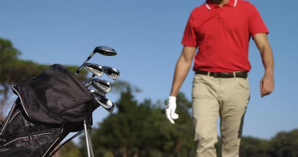 Male golfer removing golf club from golf bag