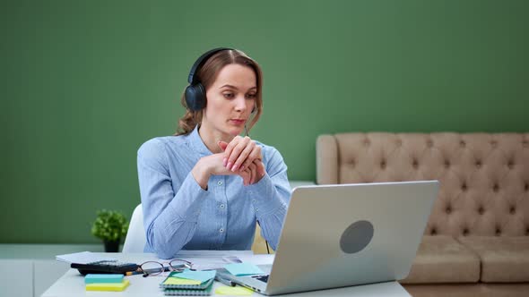 Attractive Blonde Girl in Earphones Communicating Using Webcam Computer