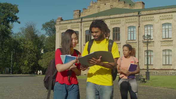 Diverse College Students Walking To Class Outdoors