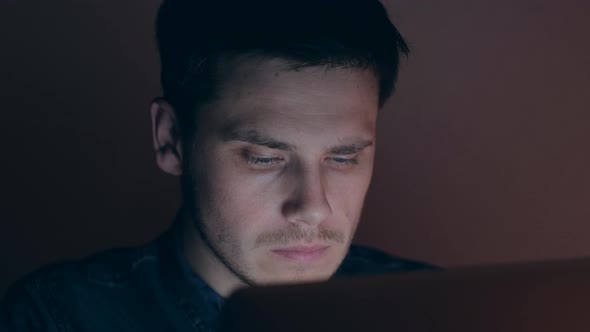 Man working on laptop at night.