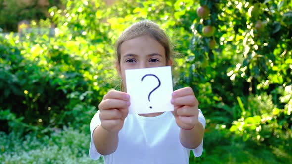 Children Shows a Question Mark on Paper