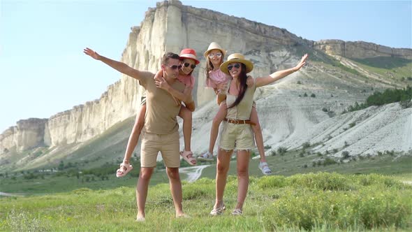 Happy Family of Four Walking in the Mountains