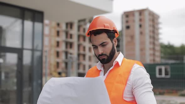 Architect Man Walking on the Construction Site and Analyzing Scheme Project Plan. Outside, Slow