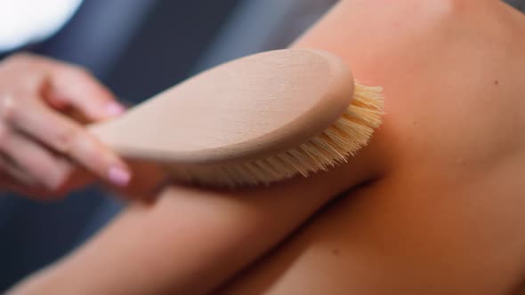 Woman Makes Massage with Anticellulite Brush on Shoulder
