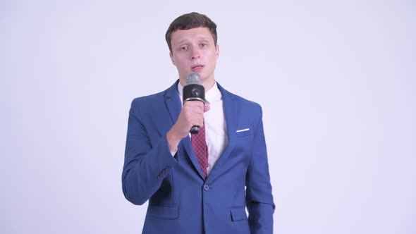 Young Handsome Businessman As Newscaster Using Microphone