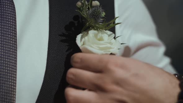 Broom Wedding preparations. Man hand holding flower in his suit