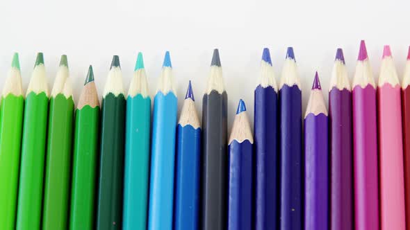 Close-up of colored pencils arranged in a wave pattern