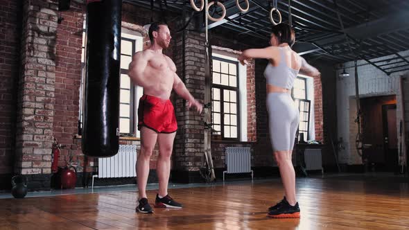 Man and Woman Warming Up Their Bodies in the Gym