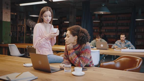 Experienced Millennial European Female Help Young African American Woman Colleague