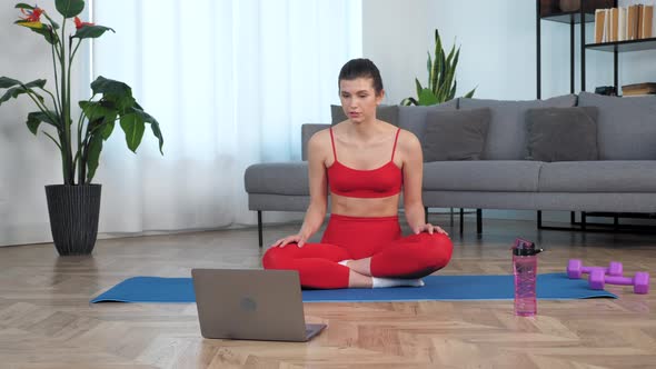 Fit Woman Sits on Yoga Mat Tells Fitness Trainer Study Online Video Call Laptop