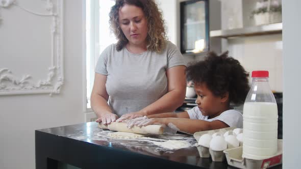 Family Baking  Black Little Girl and Her White Mother Rolling Out the Dough with a Skipping Rope