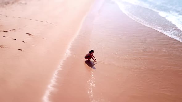 Happy Asian Woman Sitting on Sandy Beach Summer