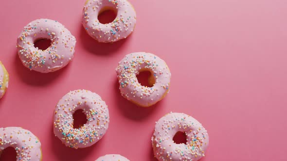 Video of donuts with icing on pink background