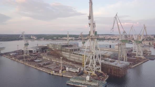 Shipyard With Cranes And Unfinished Cargo Ship