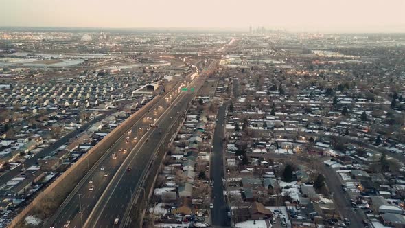 HIghway traffic of I25 highway with the downtown Denver skyline in the very far background.