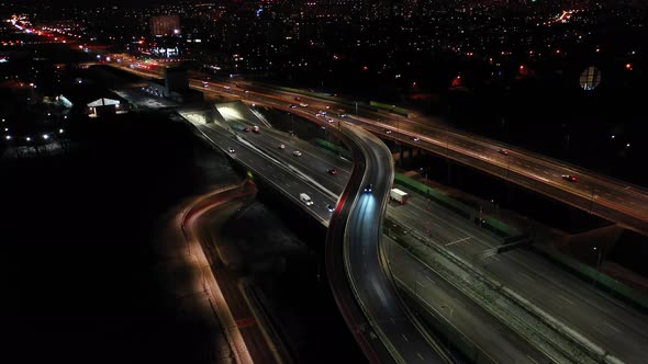 Drone shot of night traffic on a motorway showing cars and lanes of light with Tunnel and viaducts o