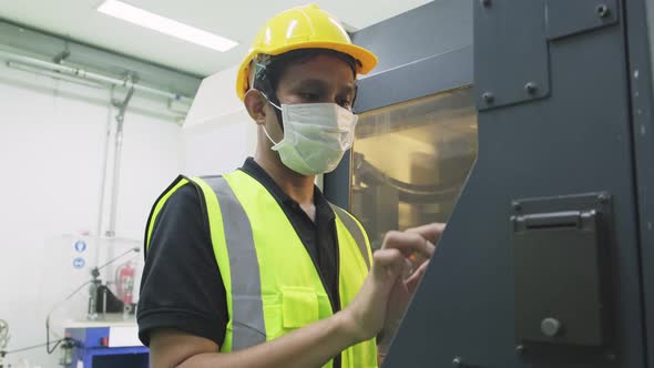 Asian male worker people wear protective safety helmet and mask work in production line of factory.