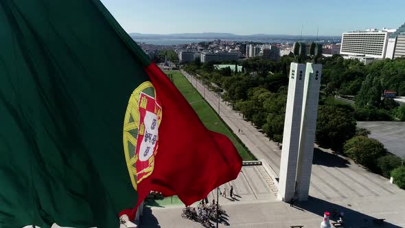 Close Up Aerial View of Portugal Flag Waving in the Wind on Eduardo VII Park Lisbon