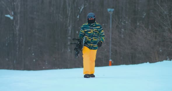 Professional Snowboarder Climbs Downhill