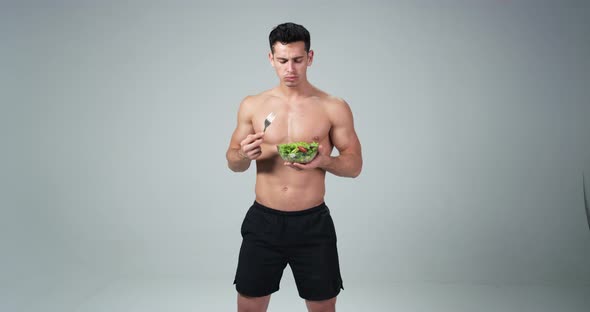 A Male Fitness Model Holding a Plastic Bowl and