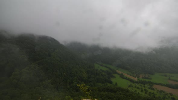 Timelapse shot with a lot of fog and dense clouds. The clouds areing very fast up the mountain. In t