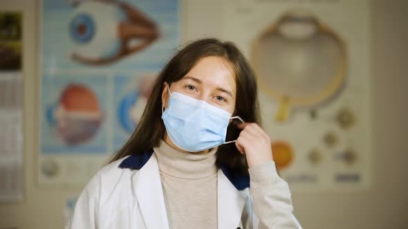 Happy Eye Doctor Takes Off Medical Face Mask and Smiles