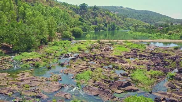 Drone Flies Over River Stone Rapids Against Boundless Jungle Pongour