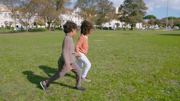 Joyful African American Friends Running and Holding Hands in Park.