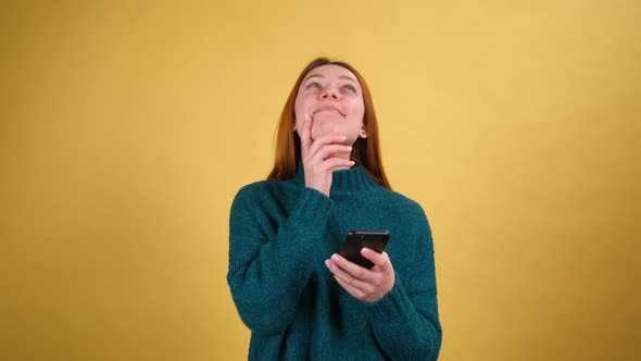 Young Red Hair Woman in Green Sweater Posing Isolated on Yellow Color Background Studio