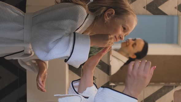 Little Girl with Mom Applying Face Creme