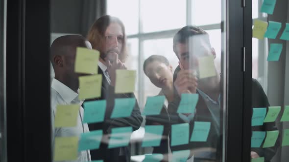 Business Meeting International Management Team at Work Team Is Standing Next To a Glass Board with