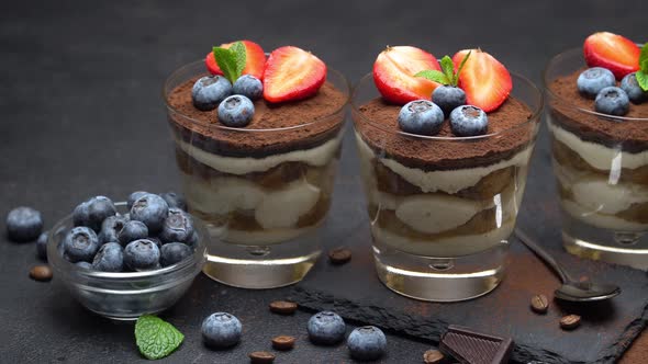 Classic Tiramisu Dessert with Blueberries and Strawberries on Stone Serving Board on Concrete