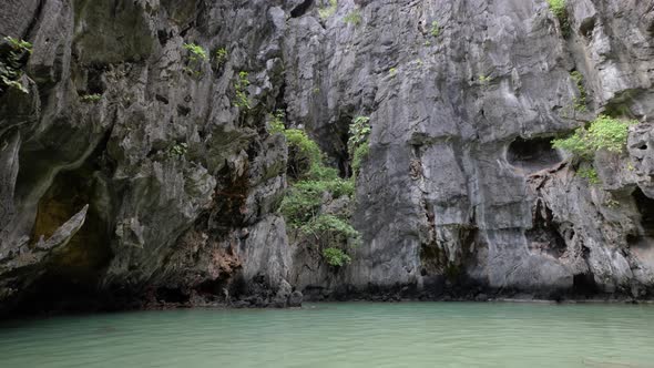 Slow motion wide angle tilt shot of limestone cliffs in Secret Lagoon in El Nido, Palawan, the Phili